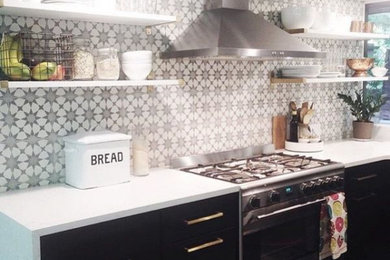 Single-wall kitchen in Other with black cabinets and stainless steel appliances.