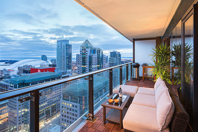 This is an example of a small contemporary balcony in Toronto with a roof extension.