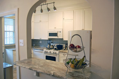 Example of a small transitional eat-in kitchen design in Baltimore with a drop-in sink, flat-panel cabinets, white cabinets, marble countertops, gray backsplash, glass tile backsplash, stainless steel appliances and an island
