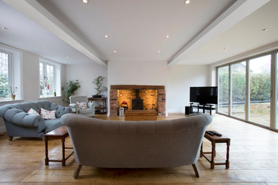 This is an example of a medium sized modern living room in Berkshire with white walls and a freestanding tv.
