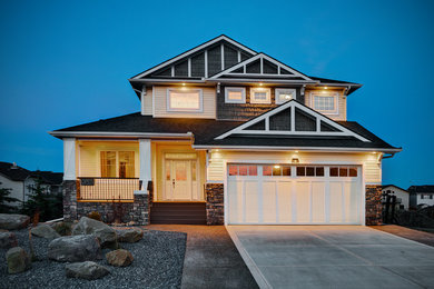 Large elegant yellow two-story vinyl gable roof photo in Toronto