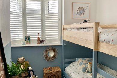 Modelo de dormitorio infantil de 4 a 10 años actual pequeño con paredes azules, moqueta y suelo beige
