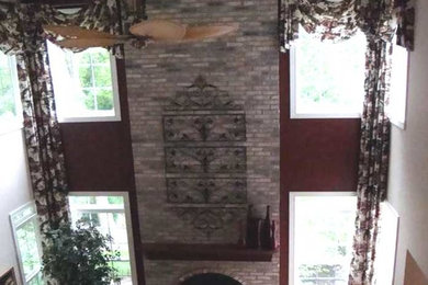 Inspiration for a rustic enclosed light wood floor family room remodel in Chicago with red walls, a two-sided fireplace and a brick fireplace