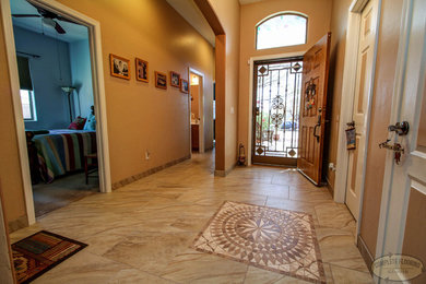 This is an example of a mid-sized transitional foyer in Phoenix with beige walls, porcelain floors, a single front door and a light wood front door.