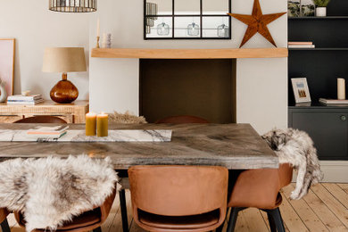 Photo of a medium sized nautical kitchen/dining room in Cardiff with white walls, light hardwood flooring, a standard fireplace, white floors and a feature wall.