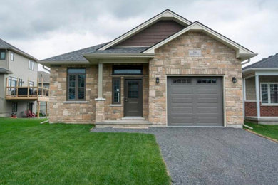Small craftsman beige one-story brick exterior home idea in Other with a shingle roof