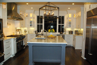 Mid-sized transitional u-shaped dark wood floor enclosed kitchen photo in New Orleans with a farmhouse sink, beaded inset cabinets, white cabinets, marble countertops, white backsplash, subway tile backsplash, stainless steel appliances and an island