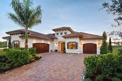 Mediterranean white two-story stucco exterior home idea in Miami with a hip roof