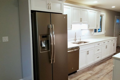 Example of a mid-sized trendy galley medium tone wood floor and brown floor open concept kitchen design in Chicago with an island, a double-bowl sink, recessed-panel cabinets, white cabinets, quartzite countertops, white backsplash and stainless steel appliances