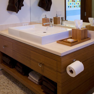 Immagine di una grande stanza da bagno con doccia minimalista con lavabo a bacinella, ante lisce, ante in legno scuro, top in marmo, WC monopezzo, pareti bianche e pavimento con piastrelle di ciottoli