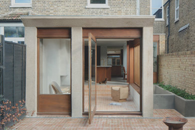 Modelo de fachada de casa pareada marrón moderna de tamaño medio de una planta con revestimiento de hormigón y tejado plano