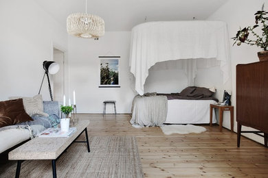 Photo of a scandinavian bedroom in Stockholm with white walls, light hardwood floors and beige floor.