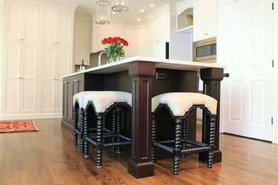 Inspiration for a large timeless l-shaped dark wood floor eat-in kitchen remodel in Other with a farmhouse sink, shaker cabinets, white cabinets, marble countertops, gray backsplash, glass tile backsplash, stainless steel appliances and an island