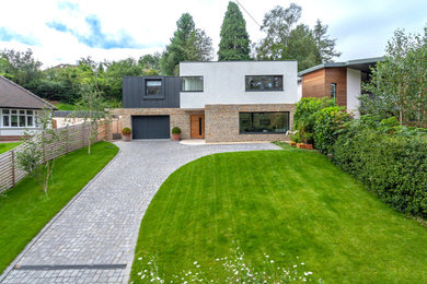 Design ideas for a medium sized modern split-level front detached house in West Midlands with metal cladding, a flat roof, a metal roof and a black roof.