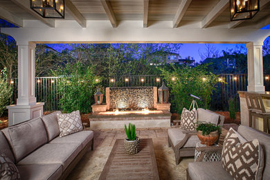 Inspiration for a small traditional backyard patio in San Diego with a water feature, concrete pavers and a pergola.