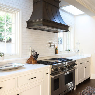 Inspiration for a large transitional single-wall kitchen pantry in San Diego with an undermount sink, recessed-panel cabinets, white cabinets, marble benchtops, white splashback, terra-cotta splashback, stainless steel appliances, medium hardwood floors and with island.