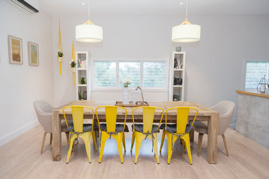 Design ideas for a large contemporary kitchen/dining combo in Melbourne with white walls, a standard fireplace, a tile fireplace surround and beige floor.