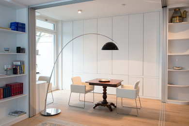 This is an example of a small contemporary dining room in Hamburg with white walls and light hardwood floors.