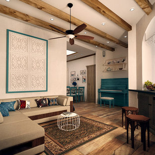 Modelo de salón con barra de bar abierto, mediterráneo, de tamaño medio, sin chimenea, con paredes blancas, suelo de madera pintada, televisor colgado en la pared y suelo marrón