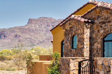 Mid-sized mediterranean brown one-story mixed siding exterior home idea in Phoenix with a tile roof