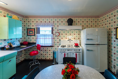 Inspiration for a mid-sized 1950s l-shaped linoleum floor enclosed kitchen remodel in Seattle with a double-bowl sink, louvered cabinets, green cabinets, yellow backsplash and no island
