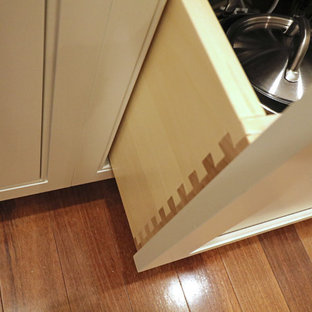 Foto på ett stort vintage kök, med en undermonterad diskho, luckor med profilerade fronter, vita skåp, bänkskiva i kvarts, grått stänkskydd, stänkskydd i keramik, rostfria vitvaror, mörkt trägolv, en köksö och rött golv