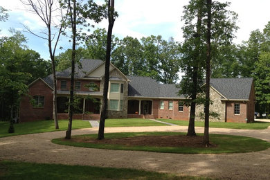 Example of a large classic red two-story brick gable roof design in Detroit