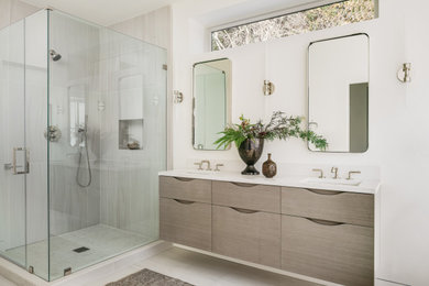 Modernes Badezimmer mit flächenbündigen Schrankfronten, hellen Holzschränken, freistehender Badewanne, weißer Wandfarbe, Quarzwerkstein-Waschtisch, Falttür-Duschabtrennung, weißer Waschtischplatte, Doppelwaschbecken und schwebendem Waschtisch in San Francisco