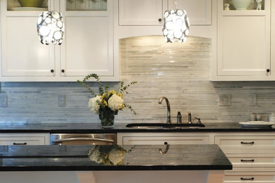 Inspiration for a transitional kitchen remodel in Minneapolis with a double-bowl sink, recessed-panel cabinets, white cabinets, granite countertops, gray backsplash, matchstick tile backsplash, stainless steel appliances and an island