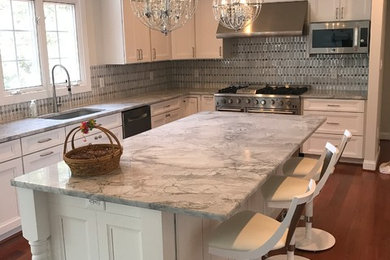 Mid-sized elegant l-shaped dark wood floor and red floor kitchen photo in DC Metro with an undermount sink, recessed-panel cabinets, white cabinets, granite countertops, gray backsplash, stainless steel appliances, an island and gray countertops