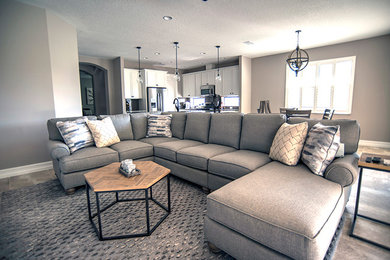 Large transitional open concept porcelain tile and beige floor living room photo in Orlando with gray walls and no fireplace