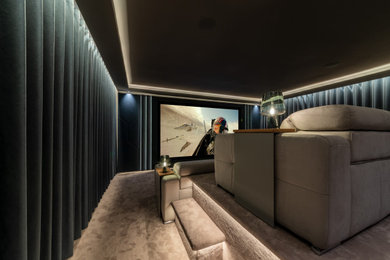 This is an example of a medium sized contemporary enclosed home cinema with grey walls, carpet, a projector screen, grey floors and a feature wall.