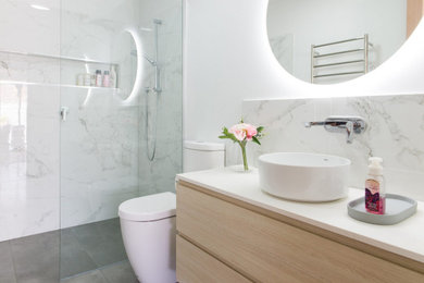 Inspiration for a mid-sized modern master bathroom in Melbourne with shaker cabinets, white cabinets, a freestanding tub, a curbless shower, a one-piece toilet, black and white tile, porcelain tile, white walls, porcelain floors, a vessel sink, marble benchtops, white floor, a hinged shower door, white benchtops, a niche, a double vanity and a built-in vanity.