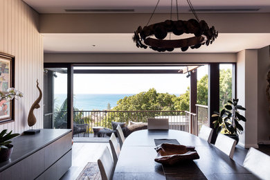 Contemporary dining room in Sydney with white walls, dark hardwood floors and brown floor.