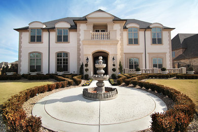 Large elegant beige two-story concrete exterior home photo in Dallas with a hip roof