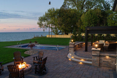 Inspiration for a mid-sized timeless backyard concrete paver and rectangular lap pool remodel in Cleveland with a bbq area