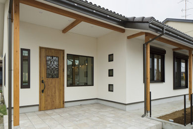 他の地域にあるモダンスタイルのおしゃれな玄関ロビー (白い壁、磁器タイルの床、木目調のドア、グレーの床) の写真