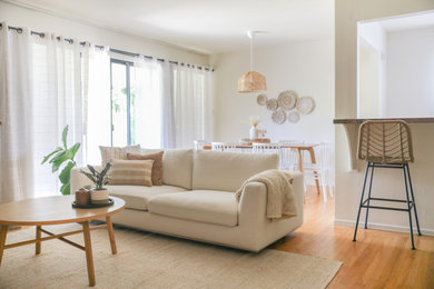 Example of a mid-sized danish open concept light wood floor living room design in San Francisco with white walls and no fireplace