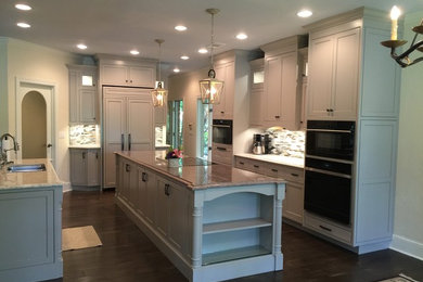 Photo of a large transitional galley open plan kitchen in Atlanta with a double-bowl sink, shaker cabinets, grey cabinets, granite benchtops, multi-coloured splashback, black appliances, dark hardwood floors and with island.