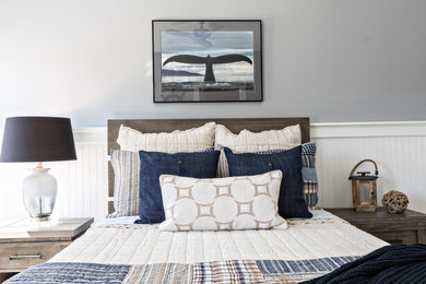 Inspiration for a large coastal guest medium tone wood floor and brown floor bedroom remodel in Other with gray walls and no fireplace