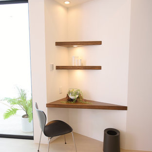 Photo of a modern study in Other with white walls, plywood flooring, no fireplace, a built-in desk and white floors.