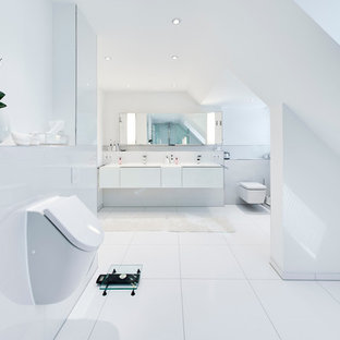Immagine di una grande stanza da bagno moderna con ante bianche, orinatoio, piastrelle in ceramica e pareti bianche