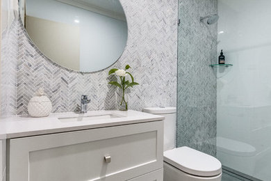 Photo of a small contemporary master bathroom in Perth with shaker cabinets, white cabinets, an open shower, a one-piece toilet, multi-coloured tile, mosaic tile, multi-coloured walls, porcelain floors, an undermount sink, solid surface benchtops, grey floor, an open shower and white benchtops.