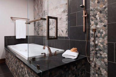 Aménagement d'une salle de bain principale craftsman en bois brun de taille moyenne avec une baignoire posée, une douche à l'italienne, un carrelage noir, un sol en galet, un lavabo encastré, une cabine de douche à porte battante, un plan de toilette gris, un banc de douche, meuble-lavabo encastré et du papier peint.