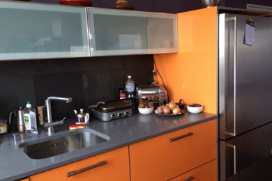 Foto de cocina lineal actual de tamaño medio abierta con electrodomésticos con paneles y una isla