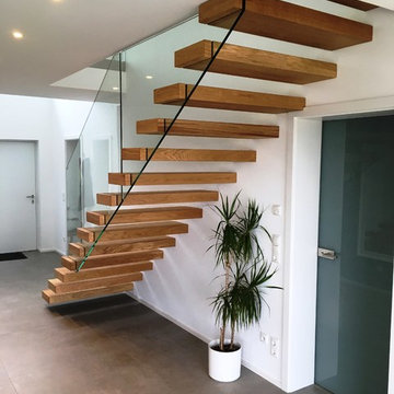 Kragarmtreppe mit Glasgeländer und Stufenverblendern