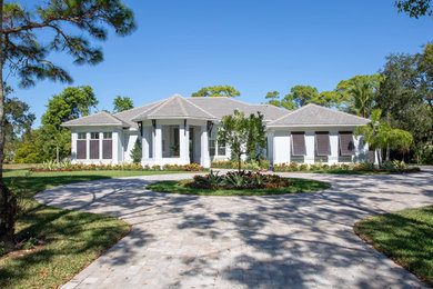 Example of a one-story stucco house exterior design in Miami with a hip roof