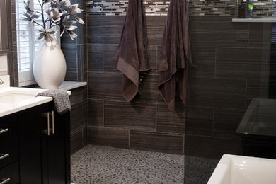 Photo of a mid-sized transitional master bathroom in Chicago with shaker cabinets, black cabinets, a freestanding tub, an alcove shower, gray tile, porcelain tile, grey walls, porcelain floors, an undermount sink, engineered quartz benchtops, grey floor and an open shower.