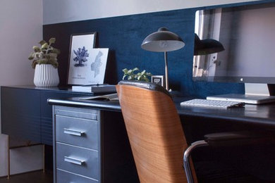 Mid-sized urban freestanding desk home office photo in Amsterdam with blue walls