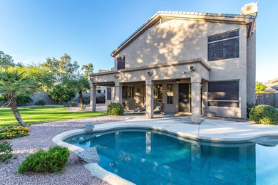 Pool - mid-sized traditional backyard concrete paver and custom-shaped pool idea in Phoenix